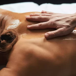 Hand massaging oiled upper back