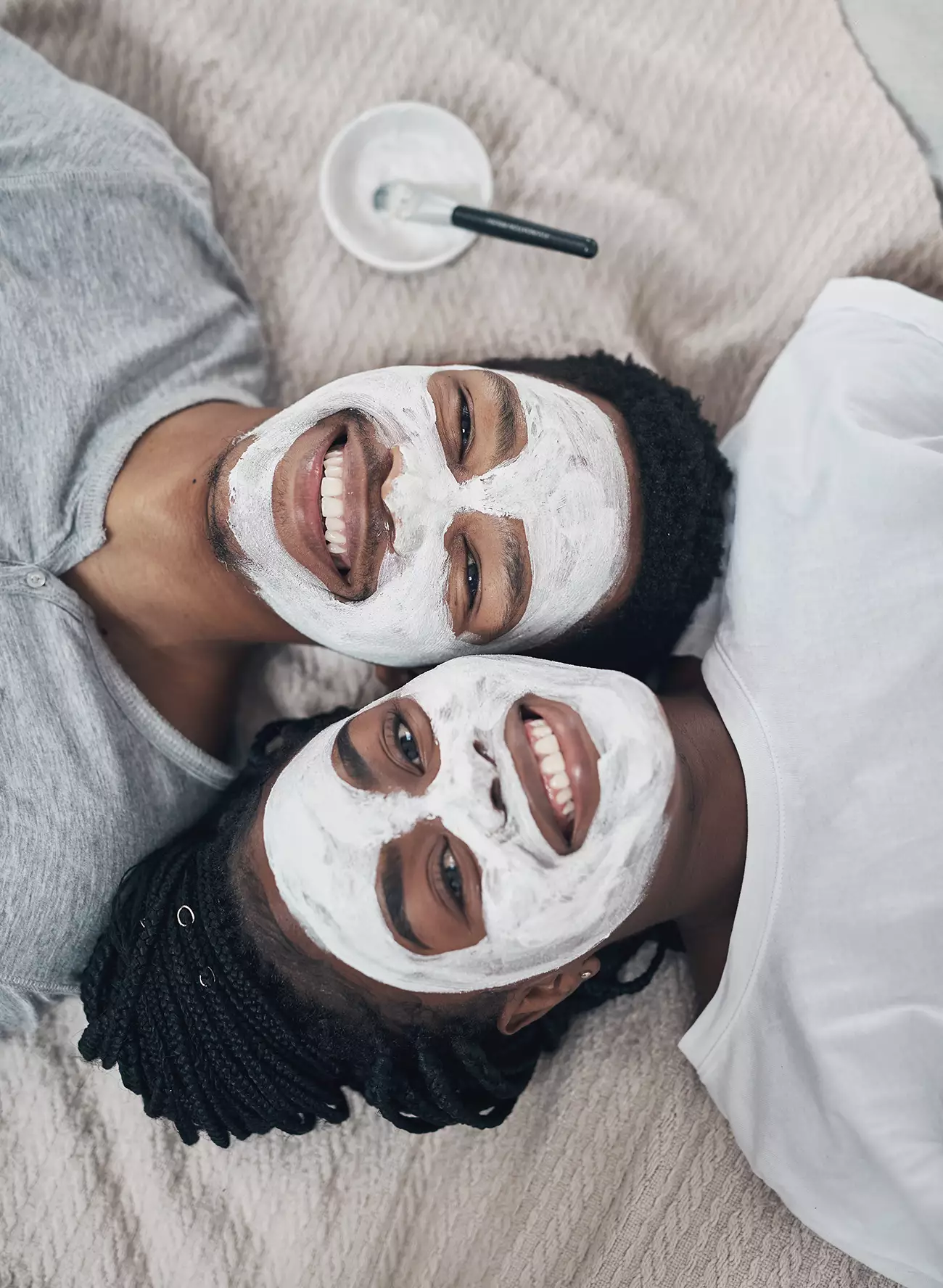 Young smiling couple with facial treatment product applied to face