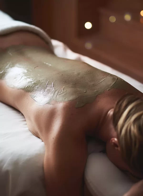 Stress relieving clay applied to the back of body during body wrap treatment