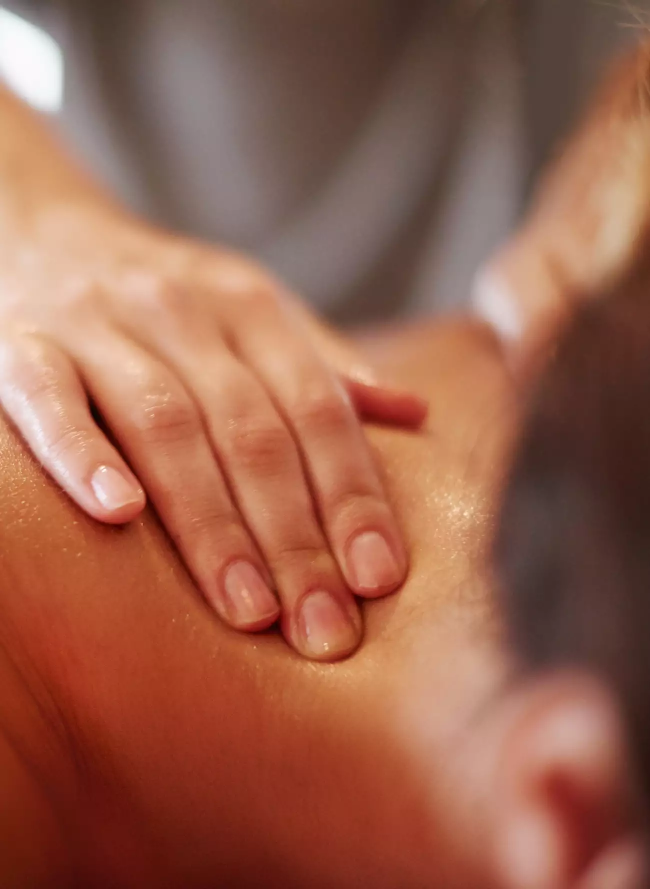 Therapist hand providing massage on upper shoulder and neck