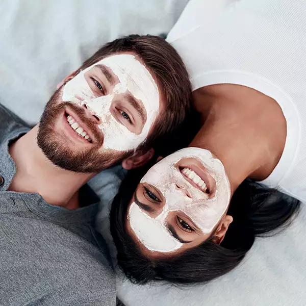 Young couple enjoying facial at day spa